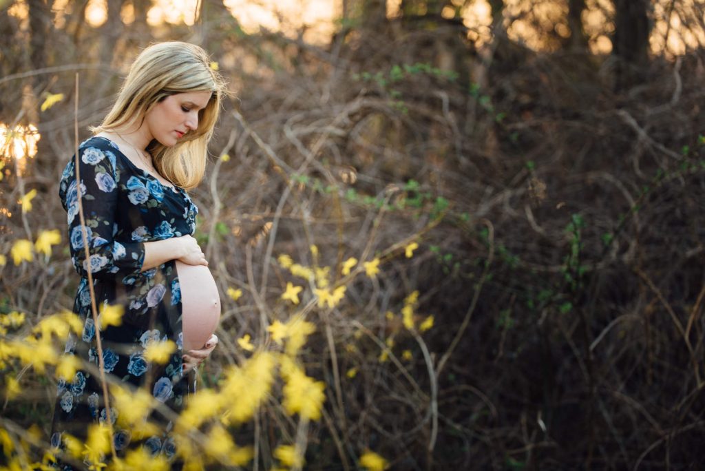 beautiful women looking down at her baby bump during her maternity session