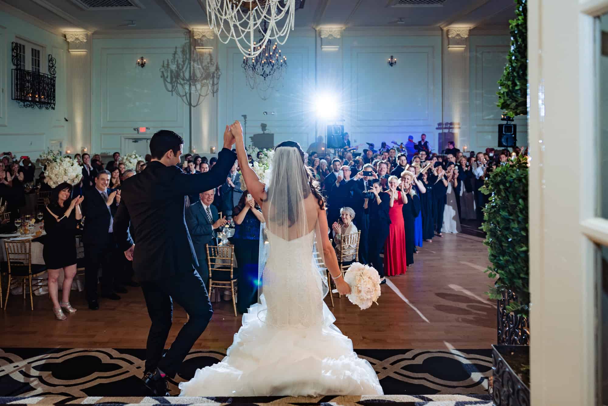 Bride and groom enter recption with hands raised in the air