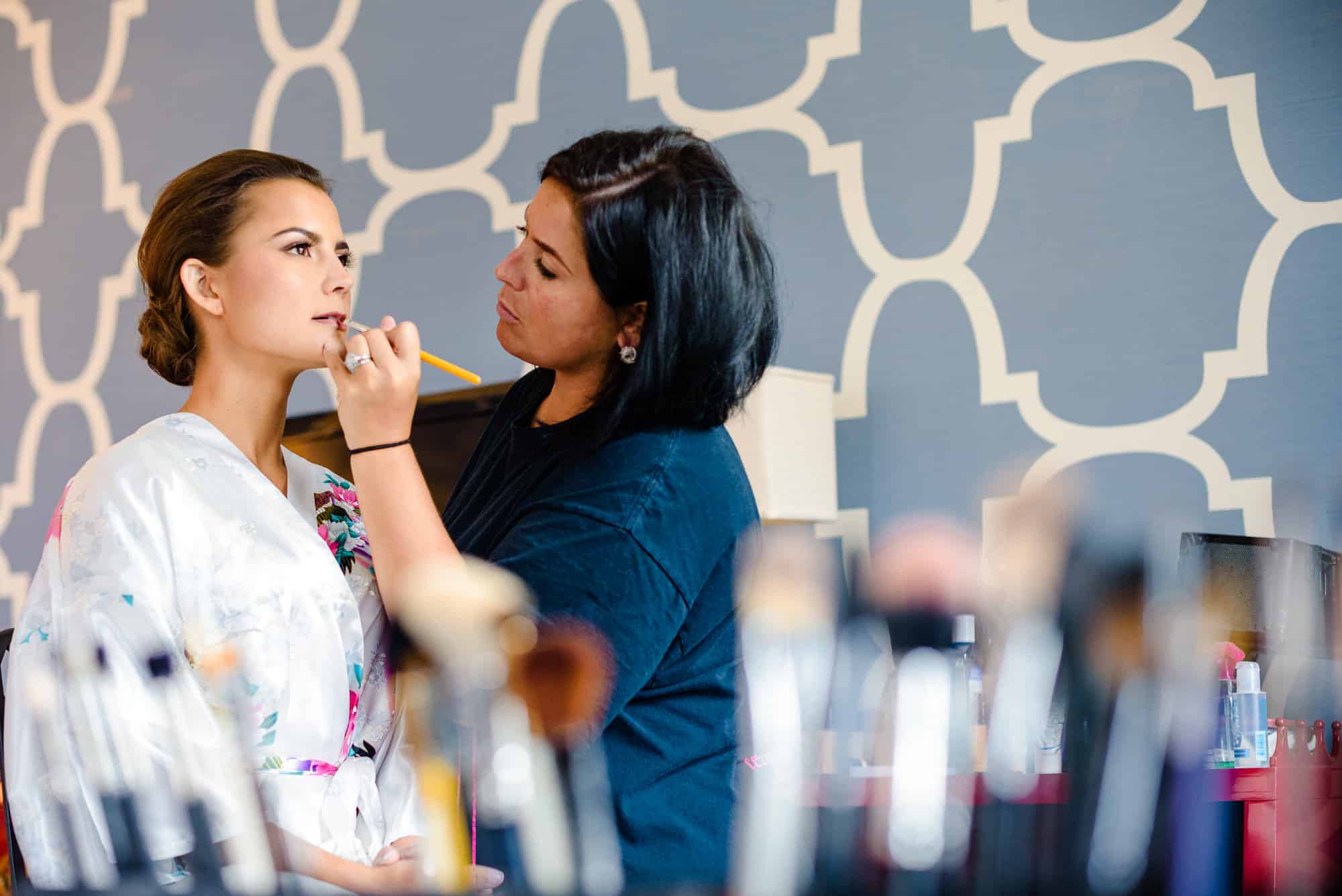 wedding makeup, artist applying lipstick to bride