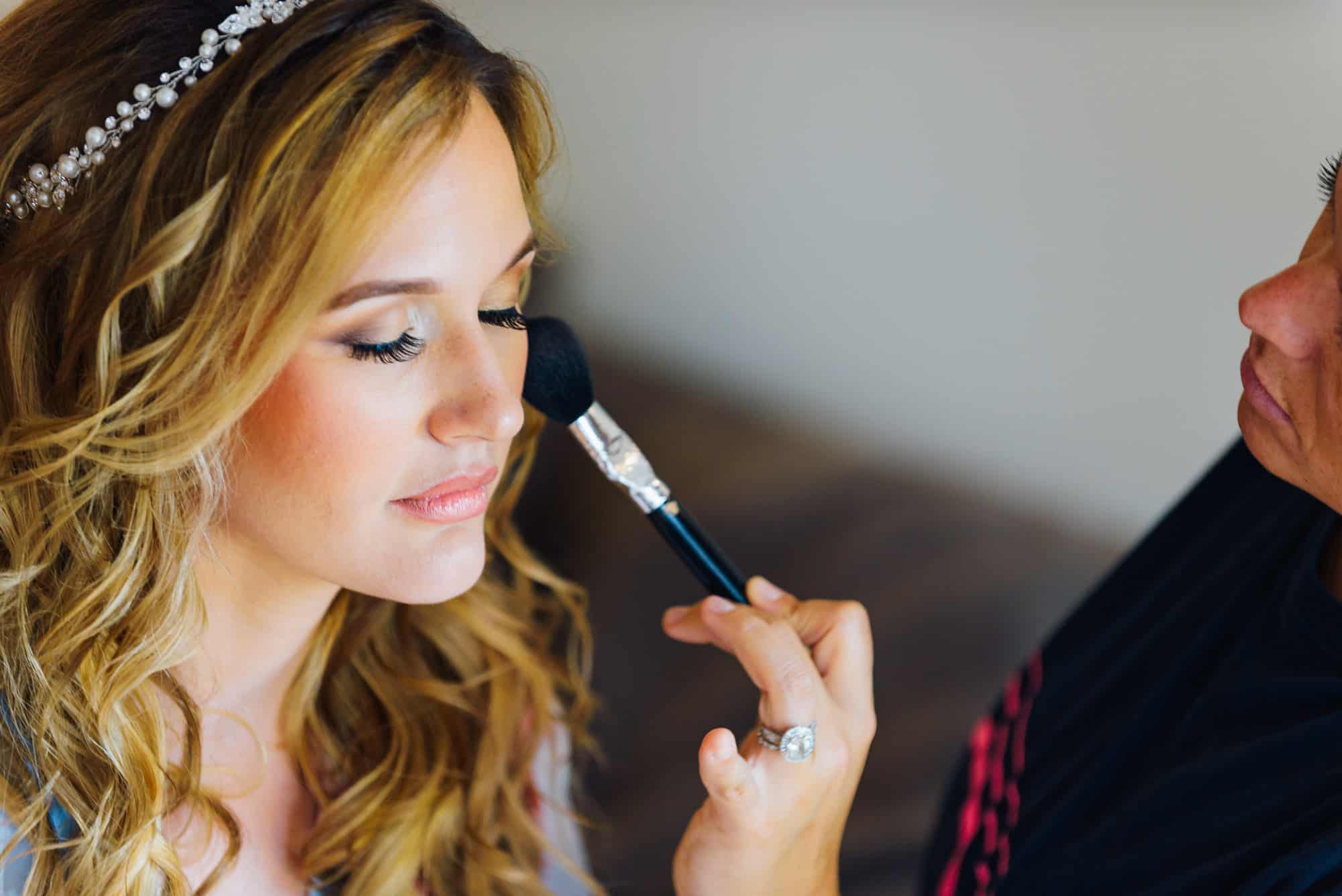 wedding makeup, artist applying blush to brides face