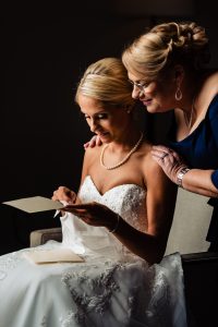 Ritz Carlton Philadelphia Wedding|mother of the bride looking over brides shoulder while she reads letter from groom