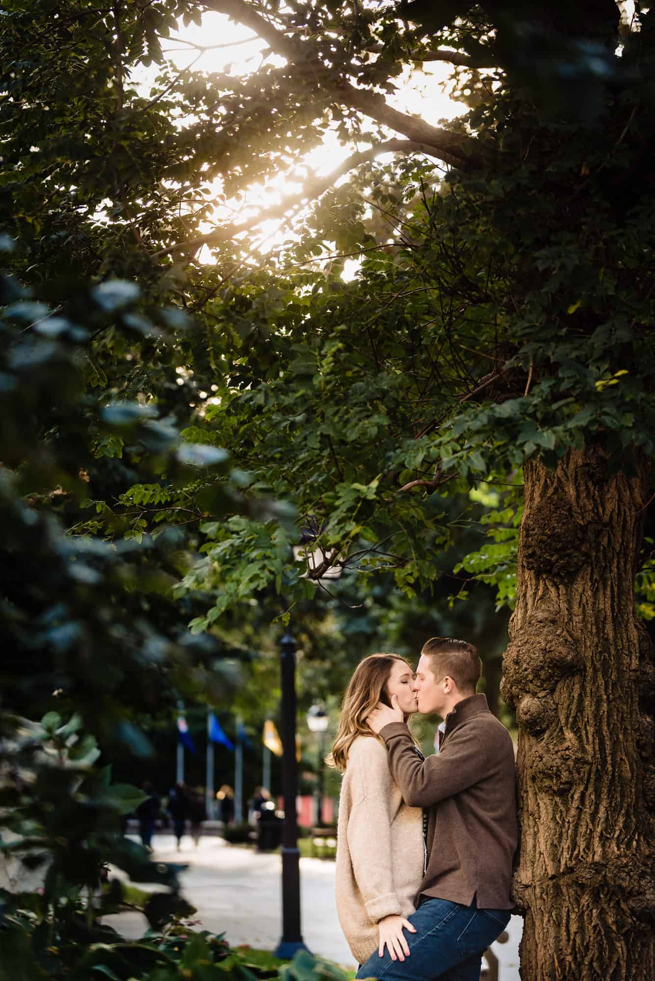 Couple kissing in front of tree in Washington Square Park