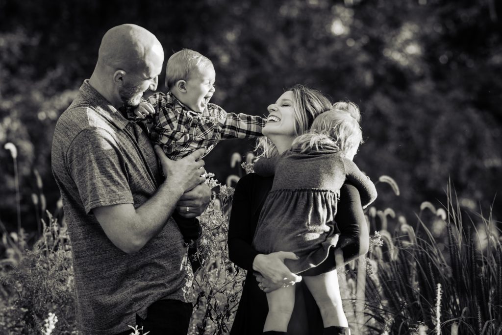 black and white candid shot of parents with their toddlers for Boosting Your Child’s Self-Esteem Through Family Photos