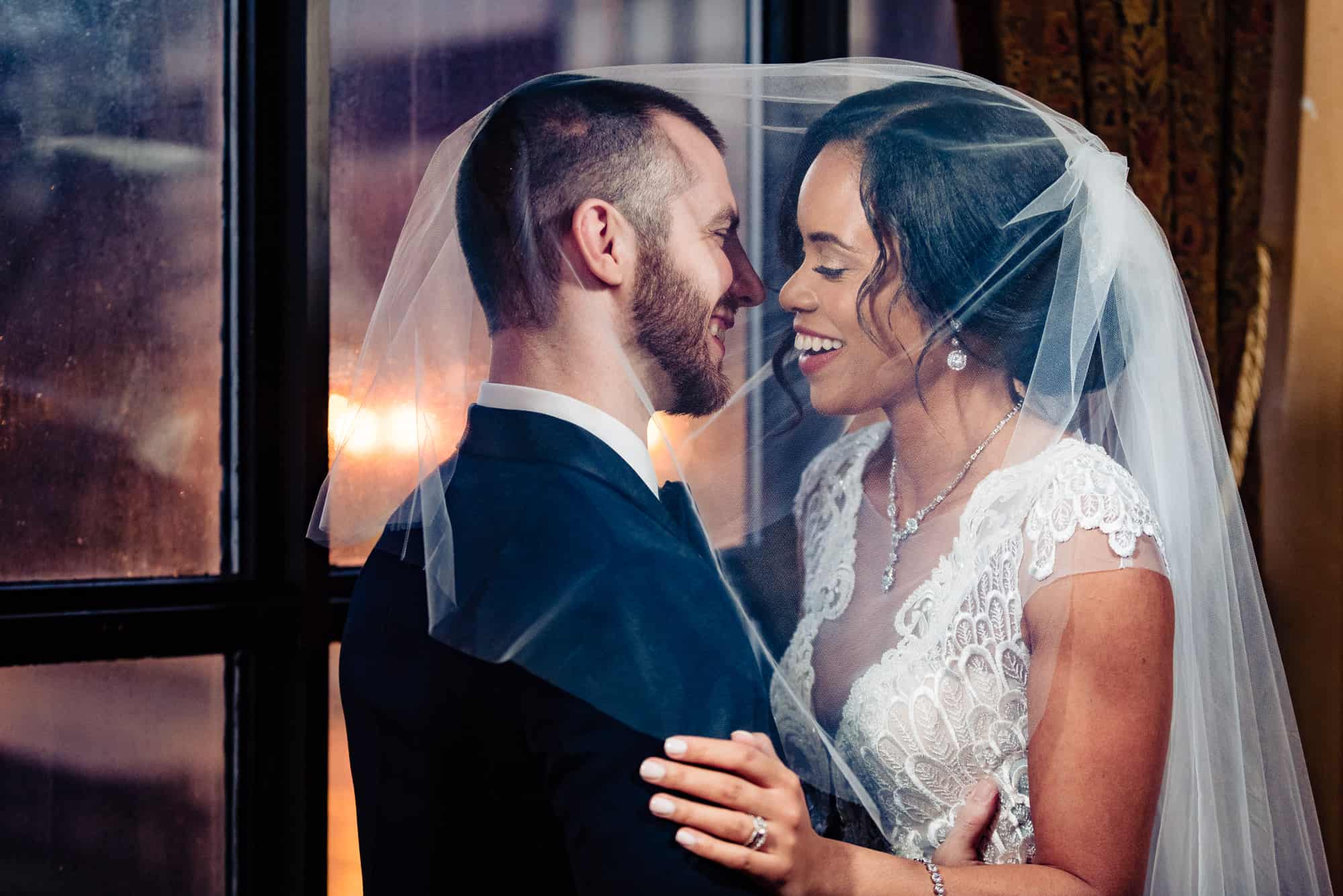 Bride and groom underneath a veil