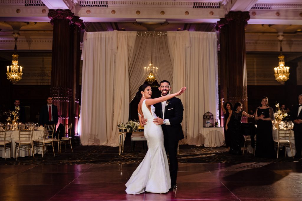 Bride and groom laughing while dancing