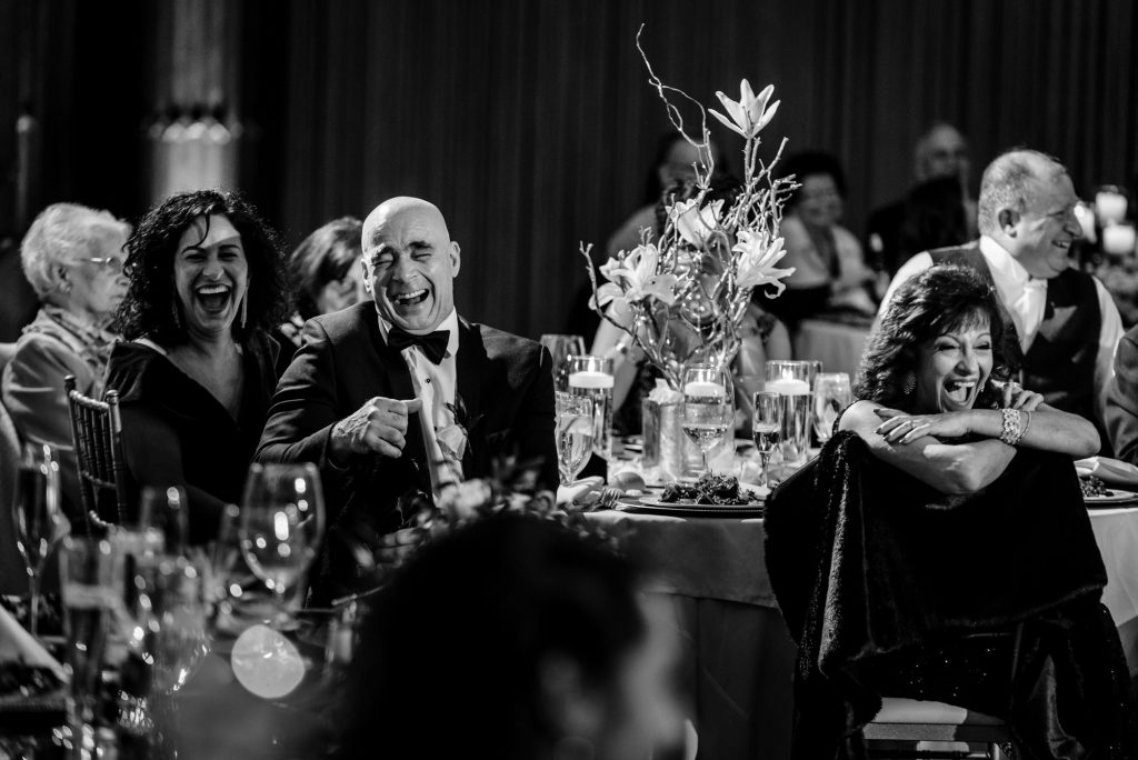 Candid image of wedding reception guests laughing