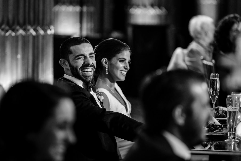 Groom laughing at wedding reception