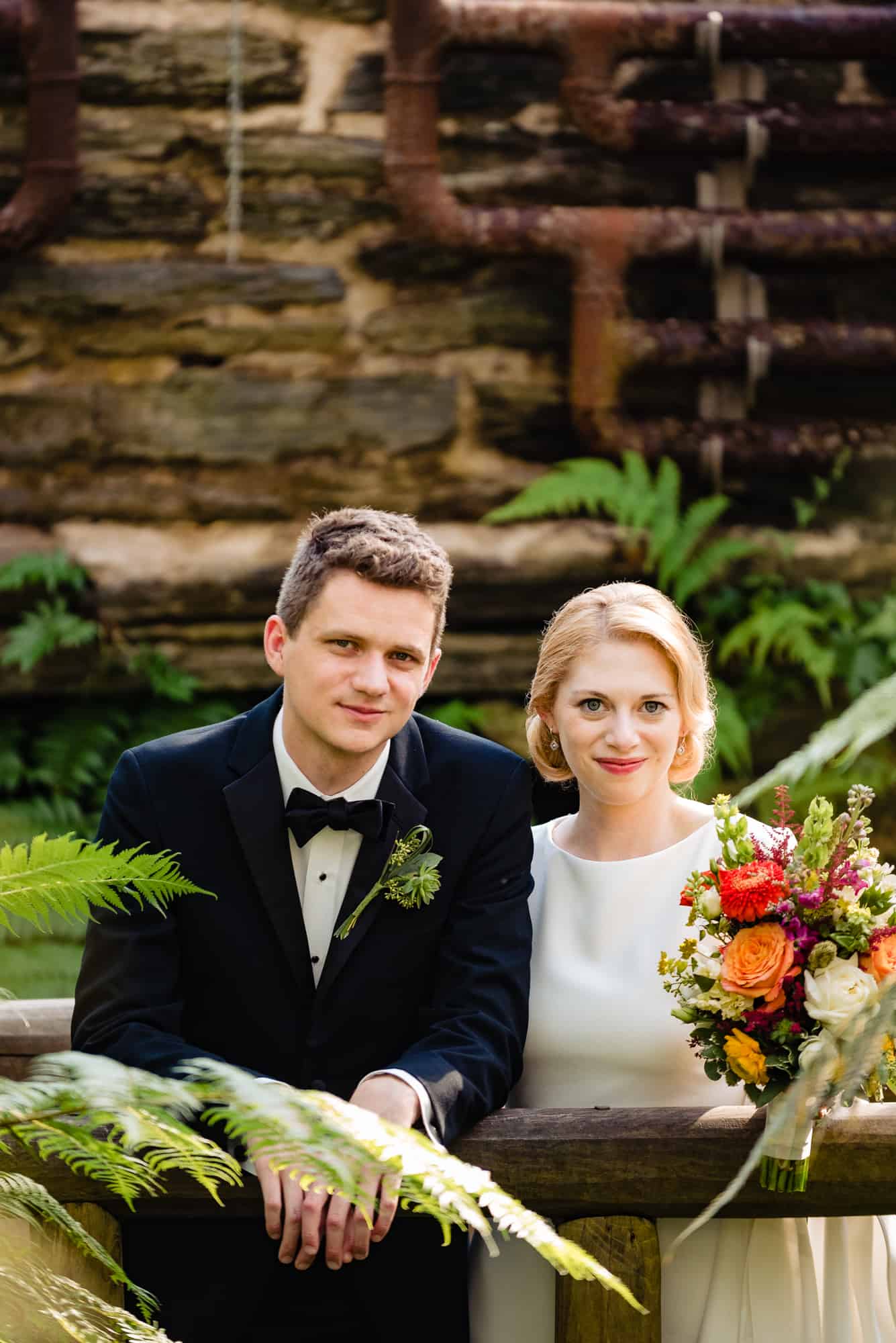 bride and groom smiles at the camera for their morris arboretum wedding