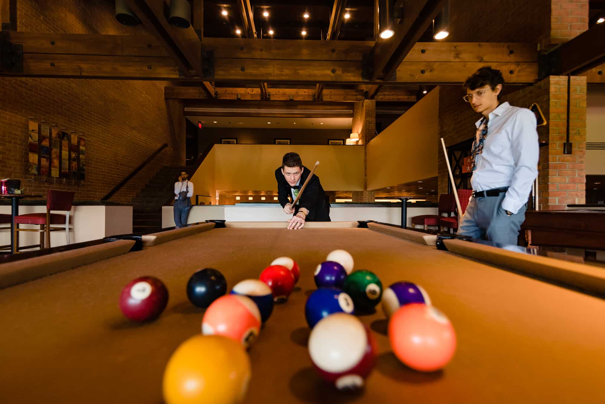 groom playing billiards before his Morris Arboretum Wedding