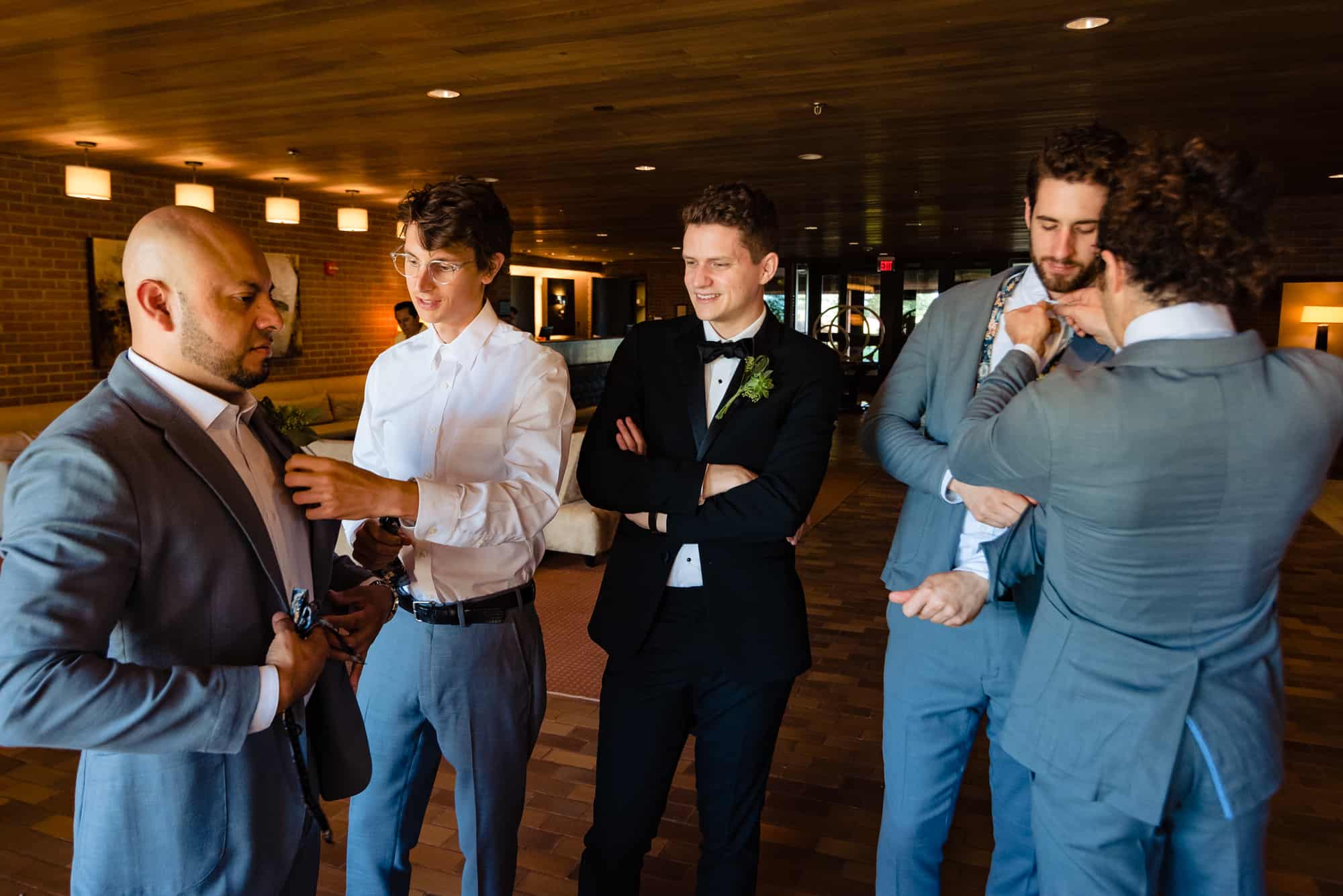 groom with groomsmen fixing each other's ties