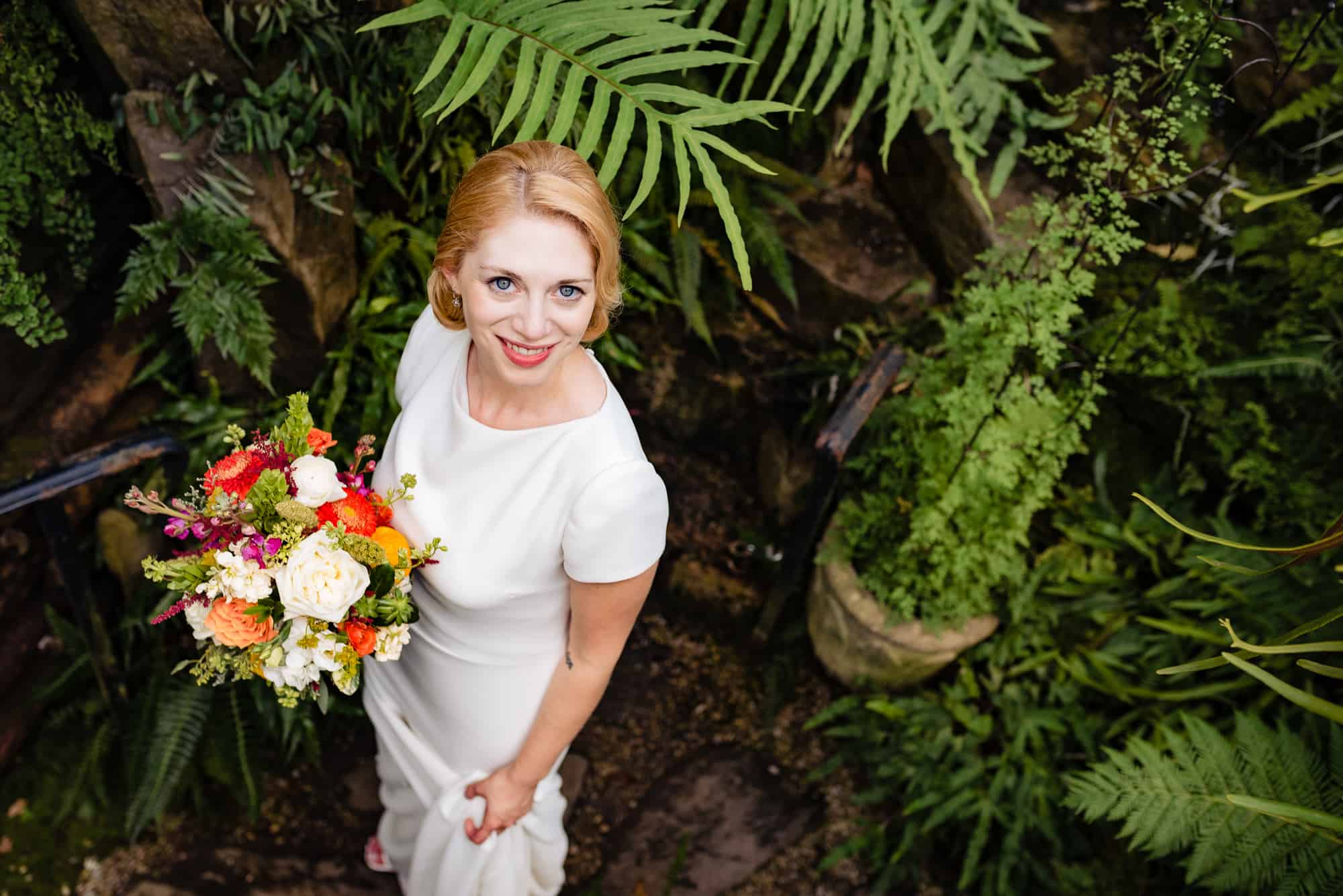 bride posing while holding her flowers at her Morris Arboretum Wedding