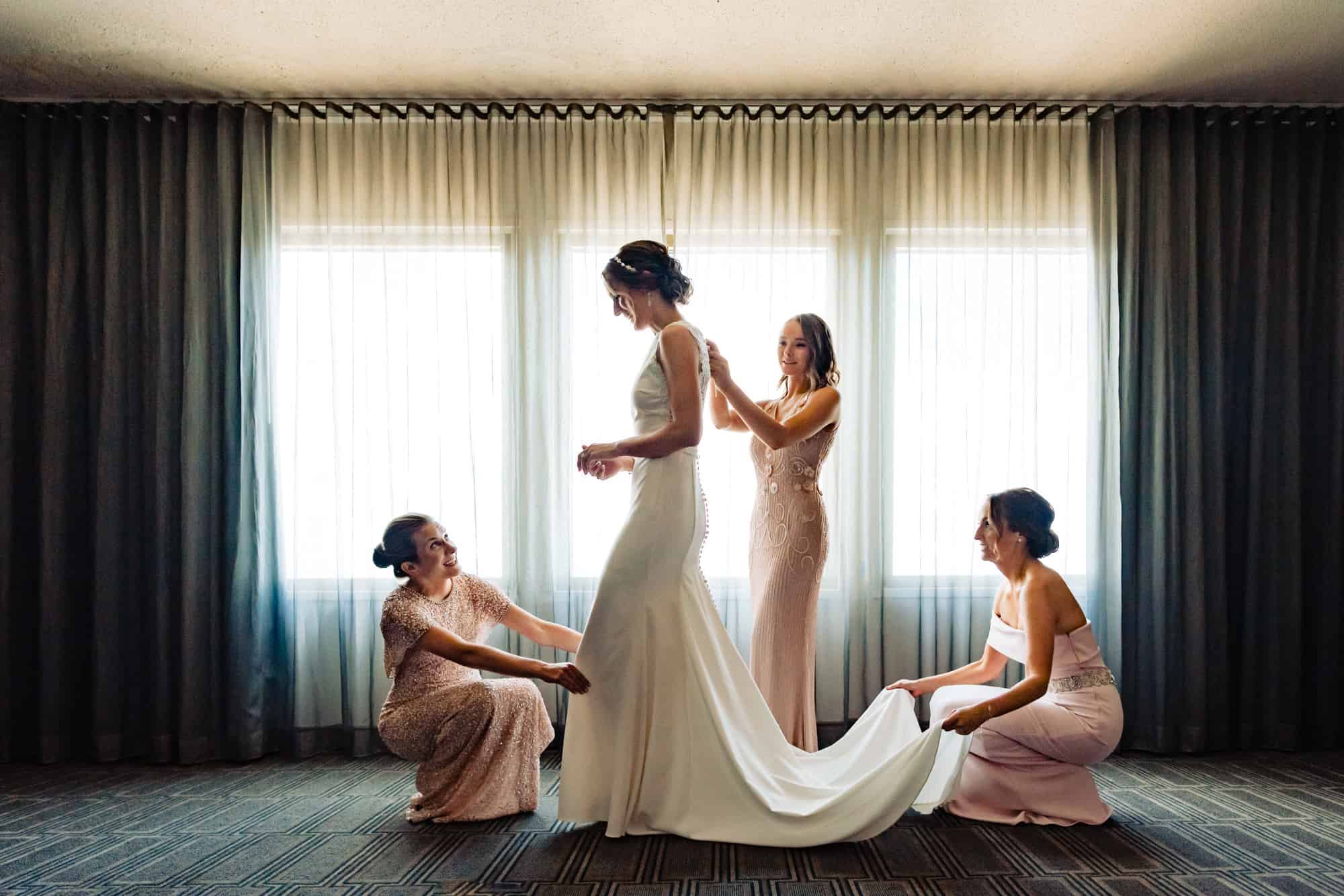 Bride getting ready with the help of her mother and maid-of-honor