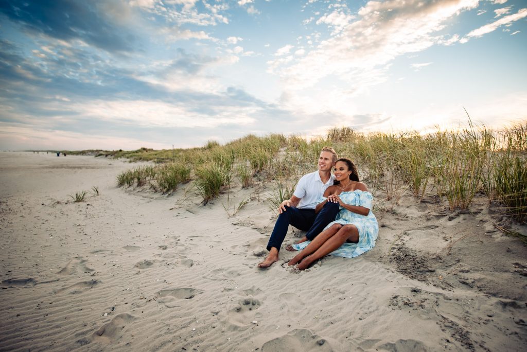 couple sitting on a beach shore during their avalon engagement photoshoot