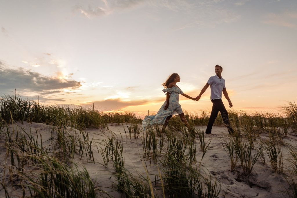 tiff & kyle walking on the beach at sunset