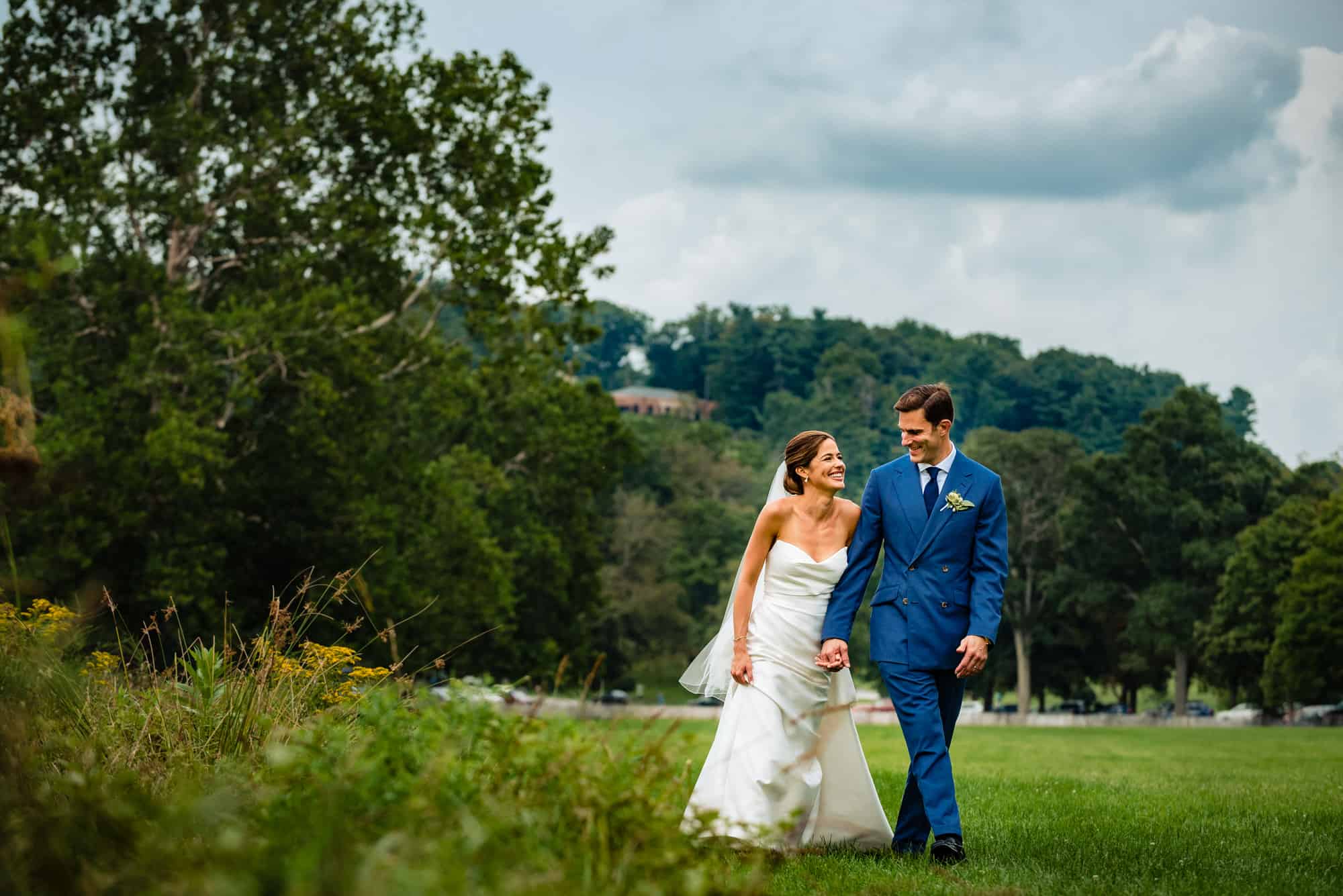 candid shot of bride and groom walking on the field