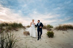 a couple walking along the beach after the wedding