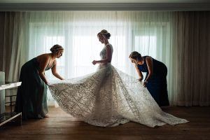 Bride with her bridesmaids fixing her gown