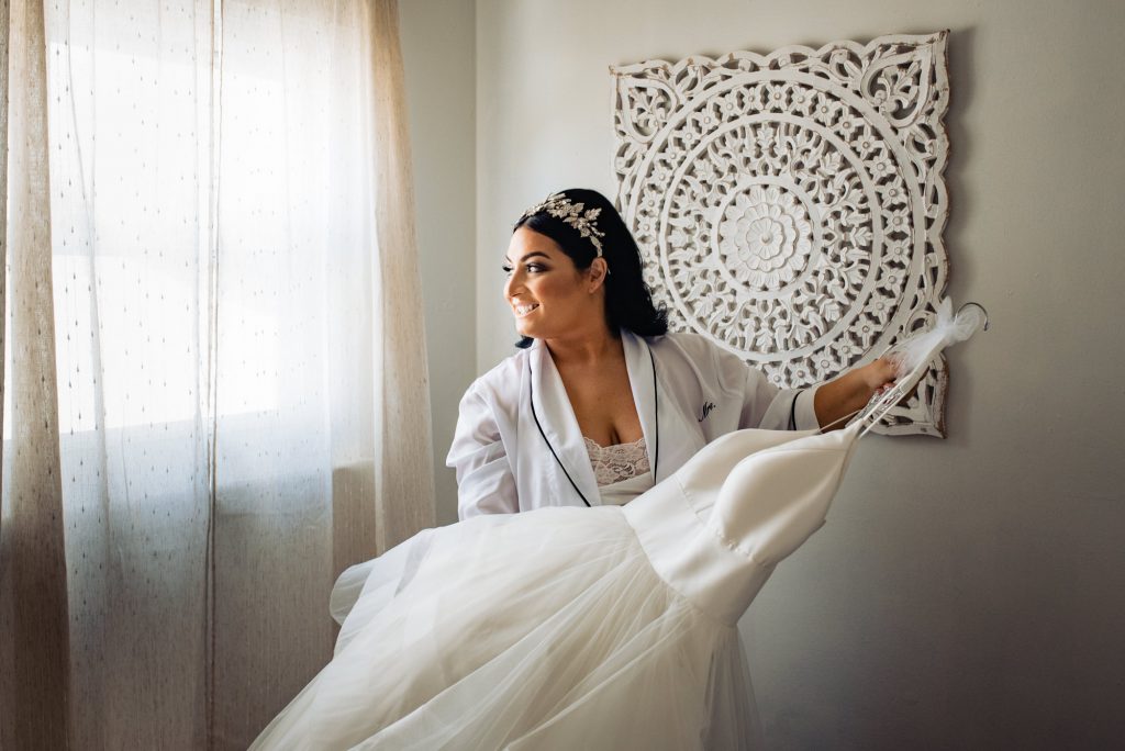 bride is carrying her wedding dress