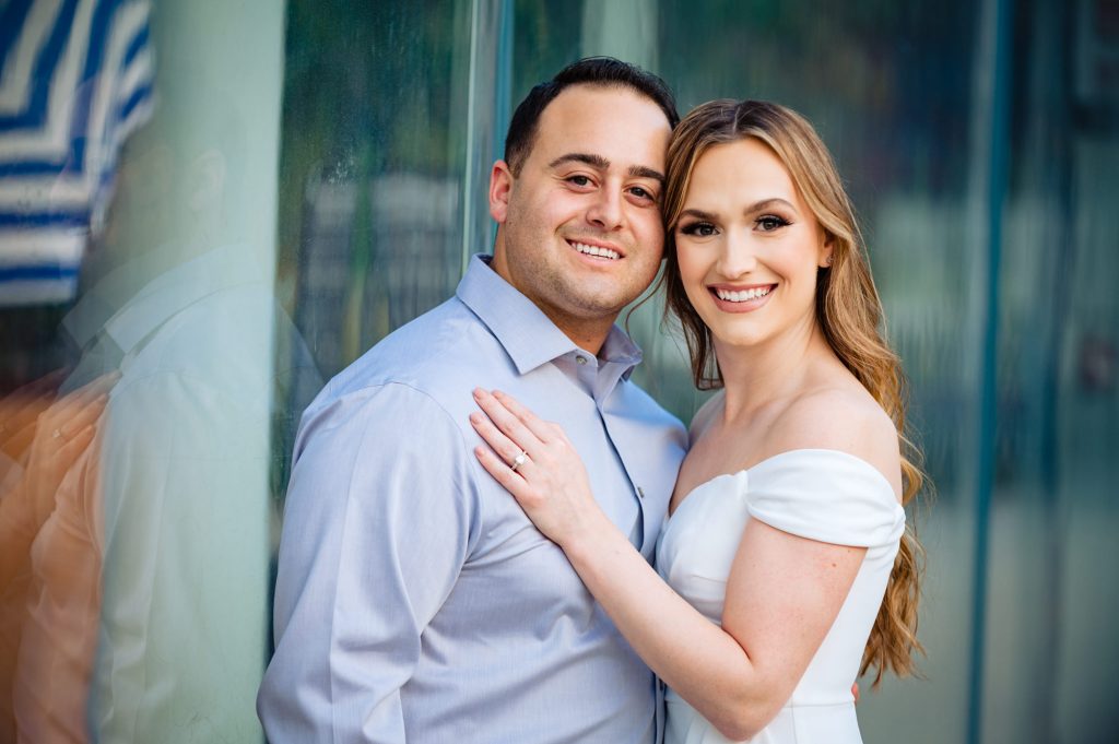 a smiling couple during their couple kisses for their Brooklyn Bridge park e-session