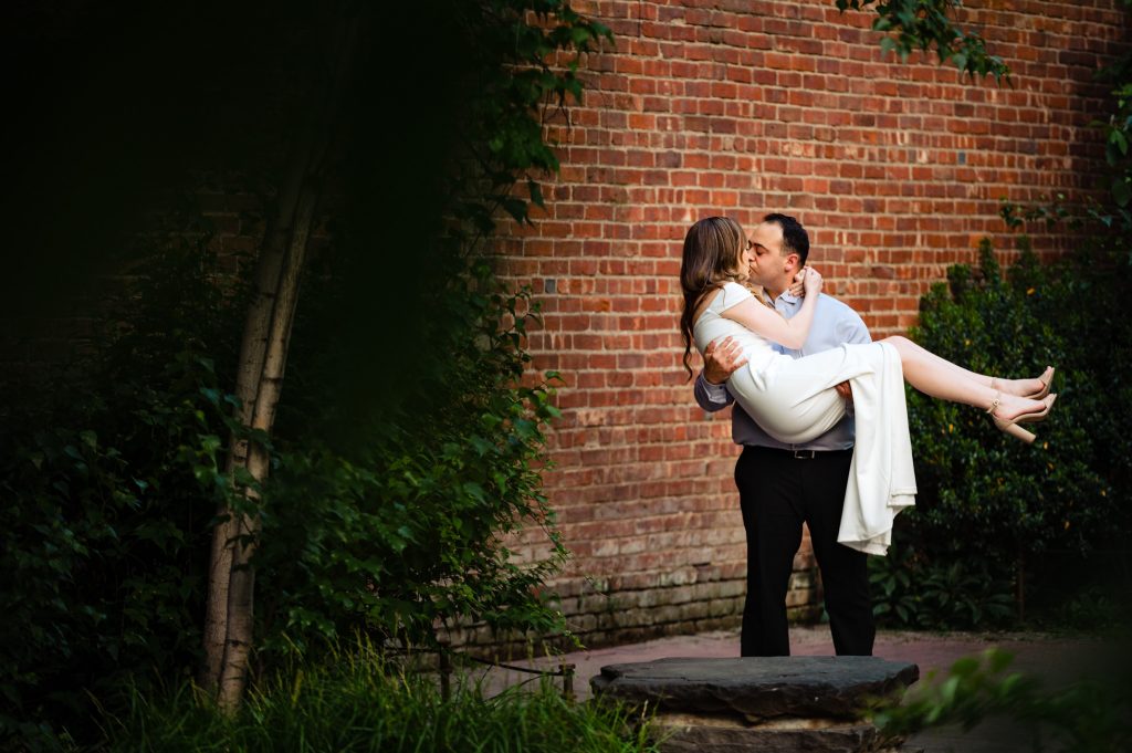 couple taking a pose during their couple kisses for their Brooklyn Bridge park e-session
