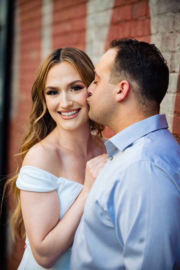 couple kisses for their Brooklyn Bridge park e-session