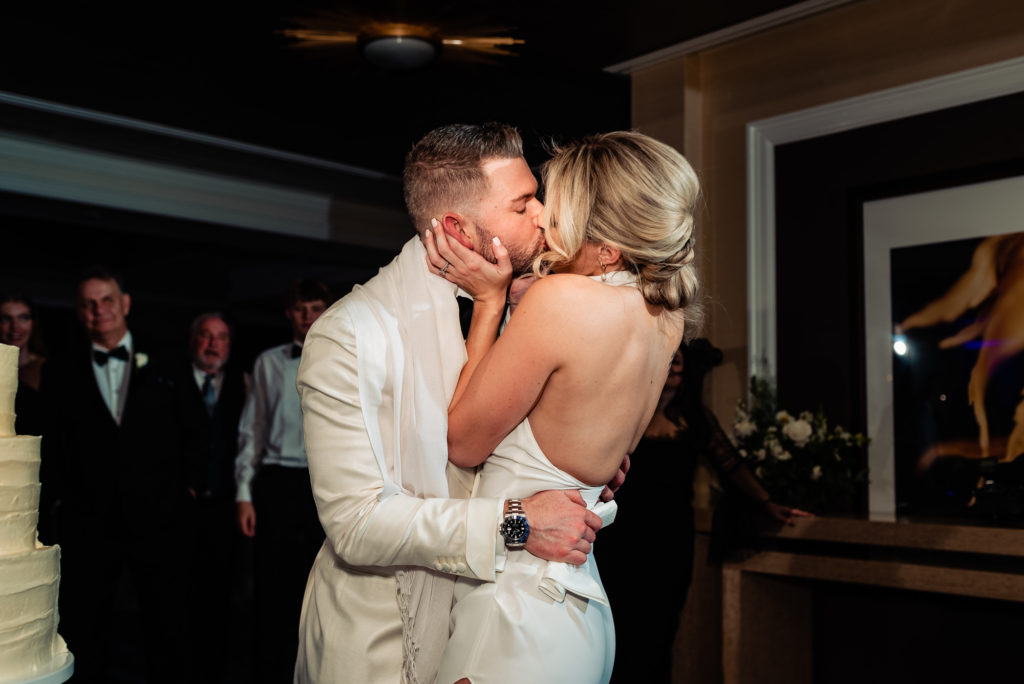 newlyweds kissing after eating their wedding cake