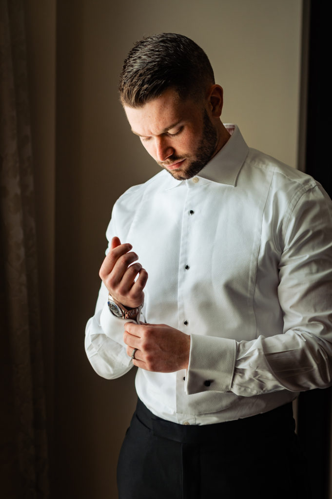 groom is fixing his sleeve