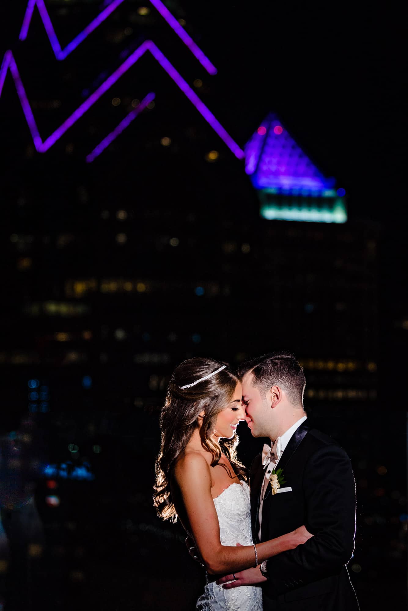 romantic night shot of bride and groom surrounded by skyscrapers at their W Hotel Wedding in Philadelphia