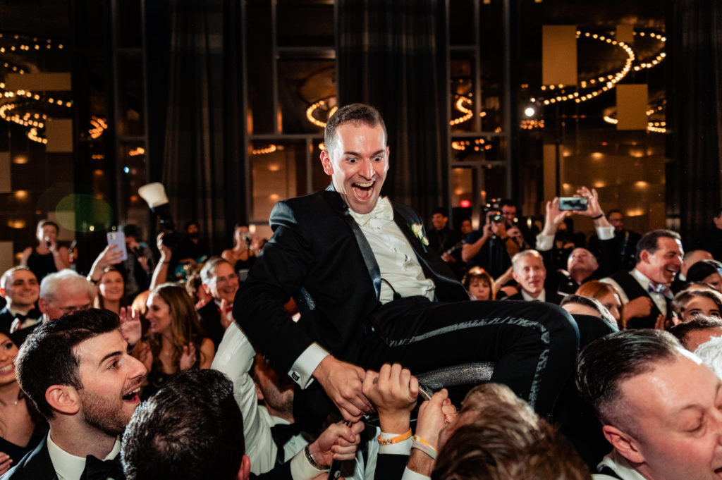 groom is carried by her guests at her wedding party W Hotel Philly