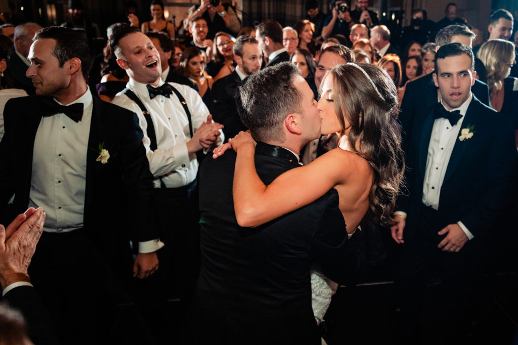 bride and groom kissing in a crowd at their W Hotel Philly wedding