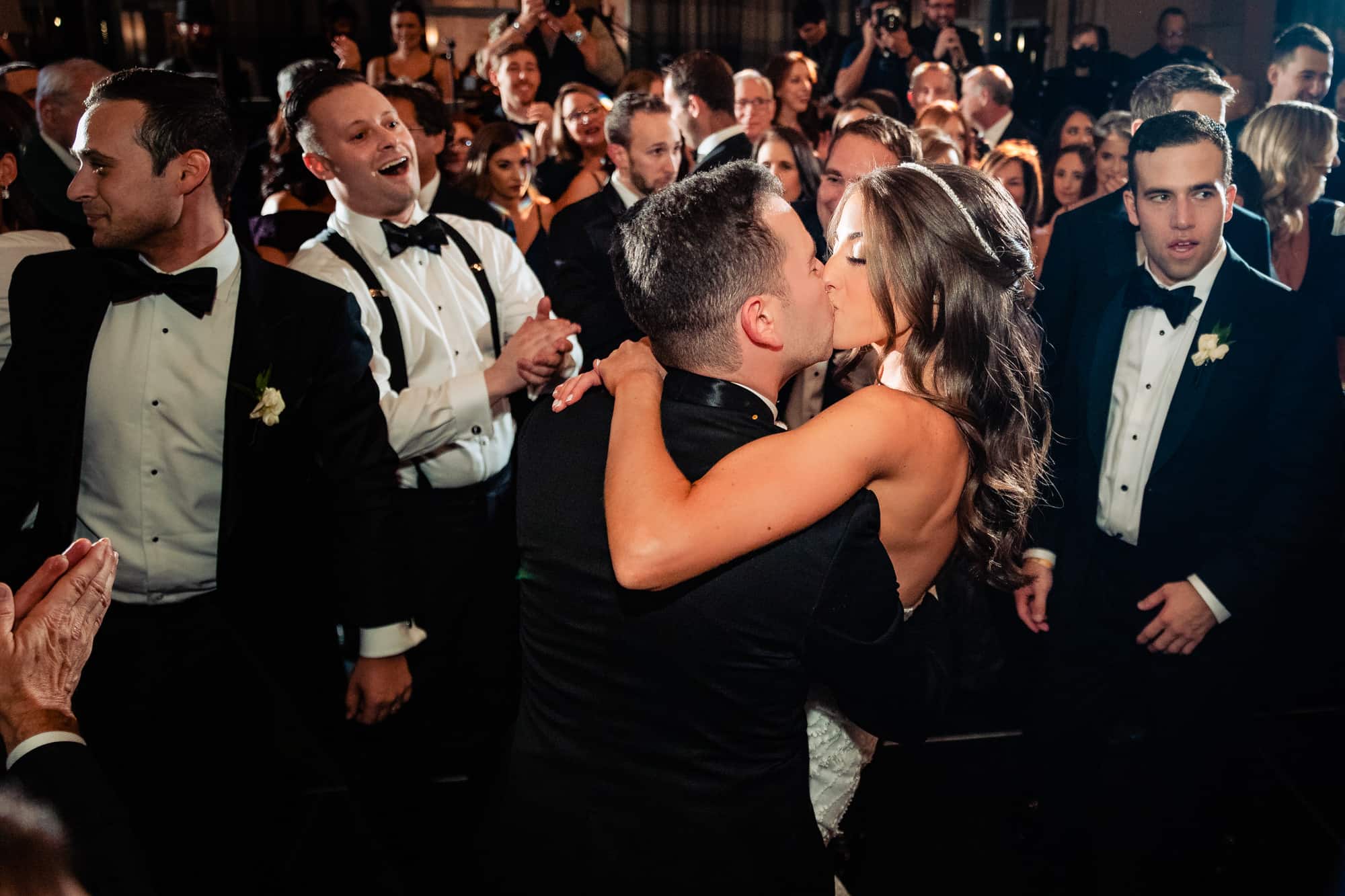bride and groom kissing in a crowd at their W Hotel Philly wedding