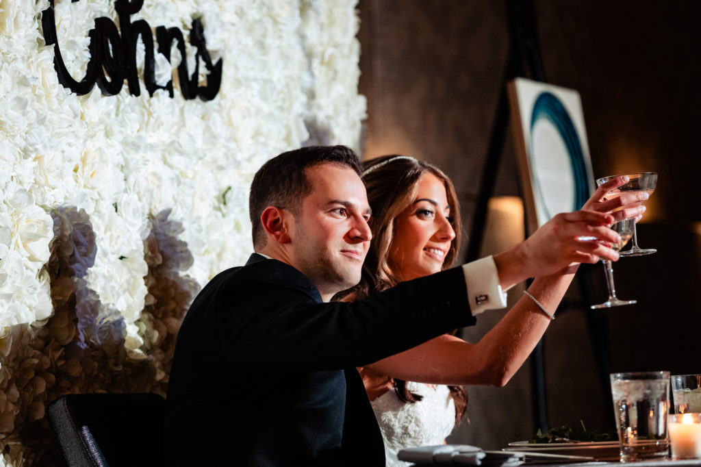 bride and groom raising their champagne glasses at their W Hotel Philly wedding