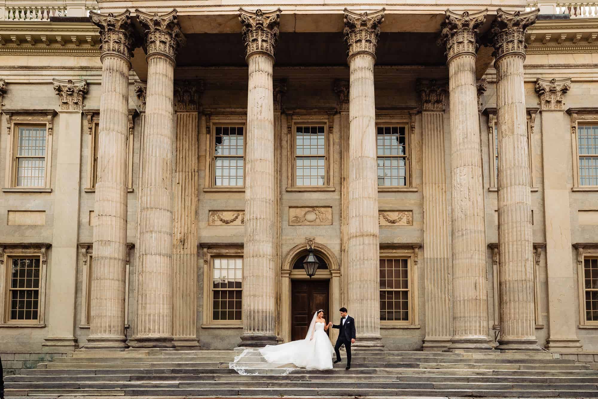 bride and groom holding hands while walking before their Crystal Tea Room Wedding