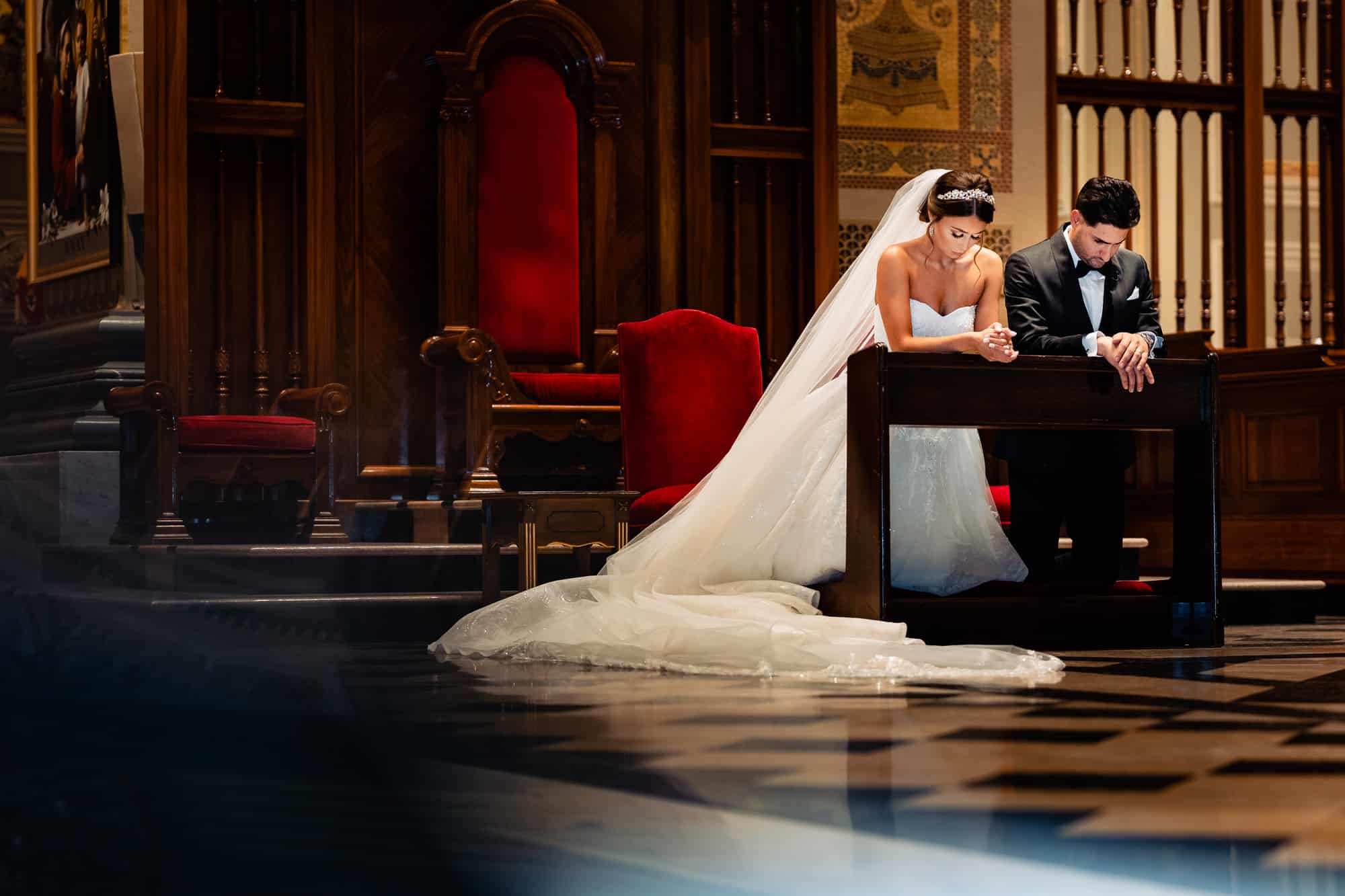 bride and groom kneeling at the altar during the church ceremony