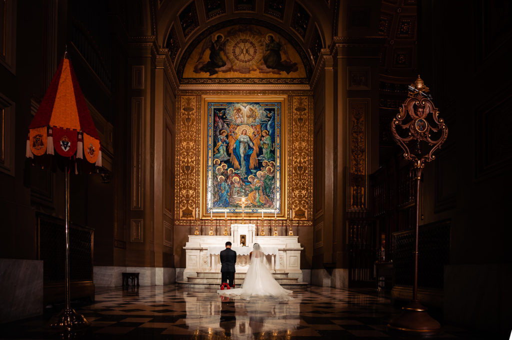 bride and groom kneeling at the altar during the church ceremony