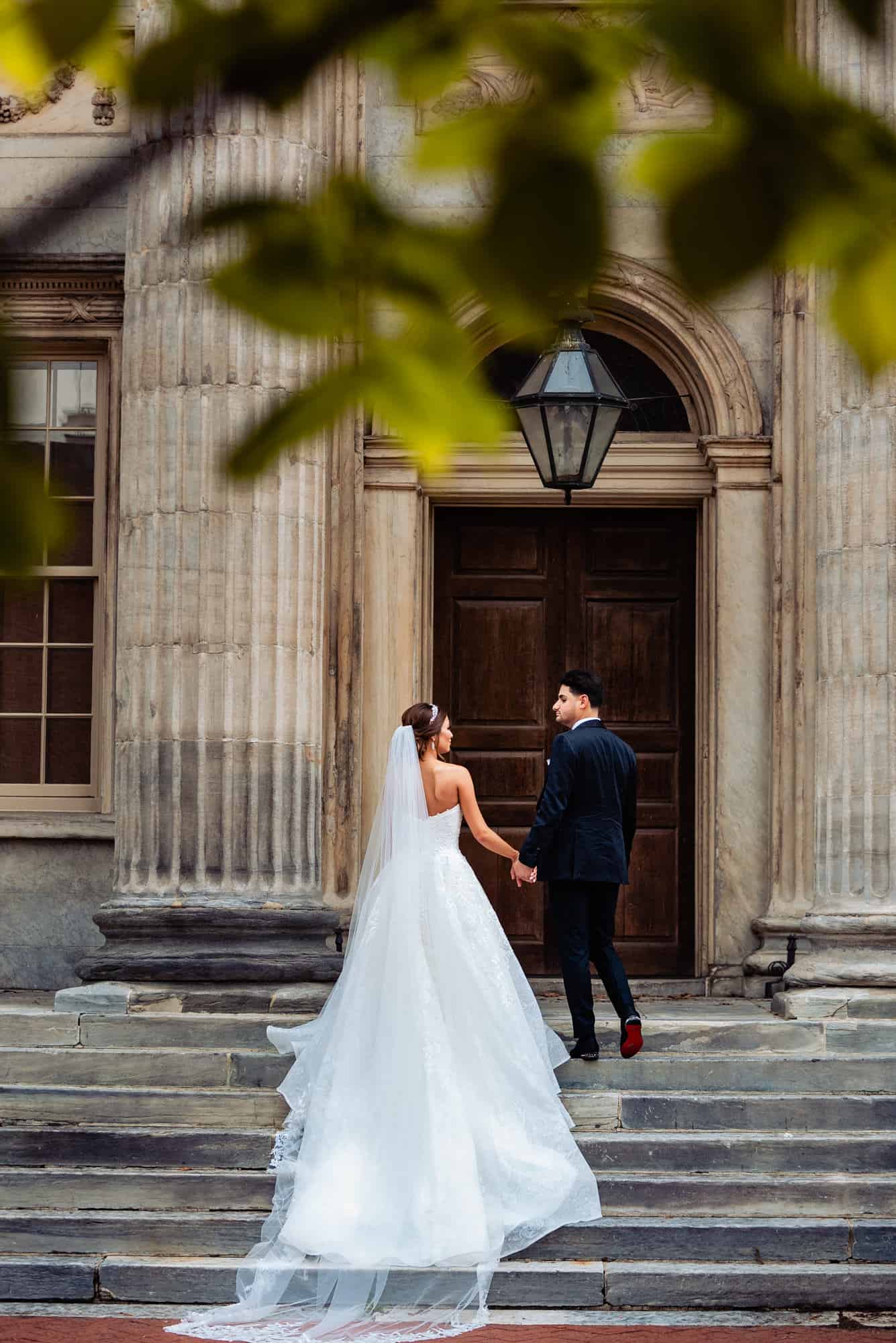 backshot of the newlyweds holding hands outside the wedding venue