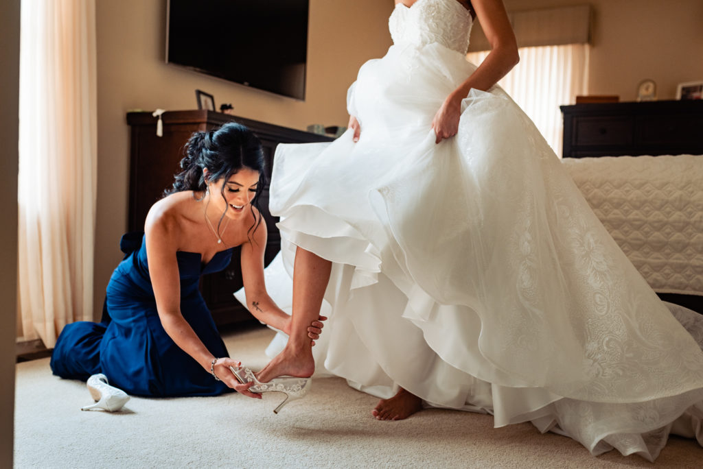 Bride getting ready with the help of her maid-of-honor