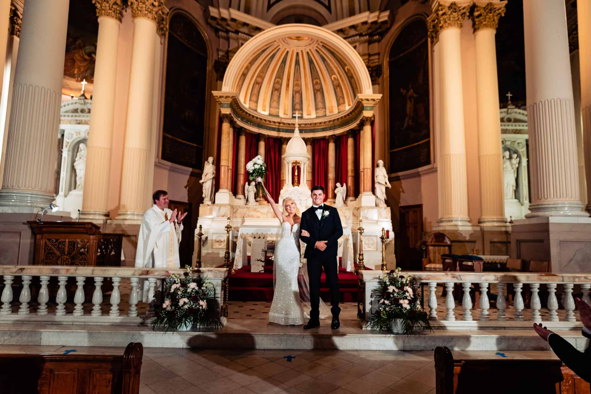 Newly married couple at the altar looking at their guests