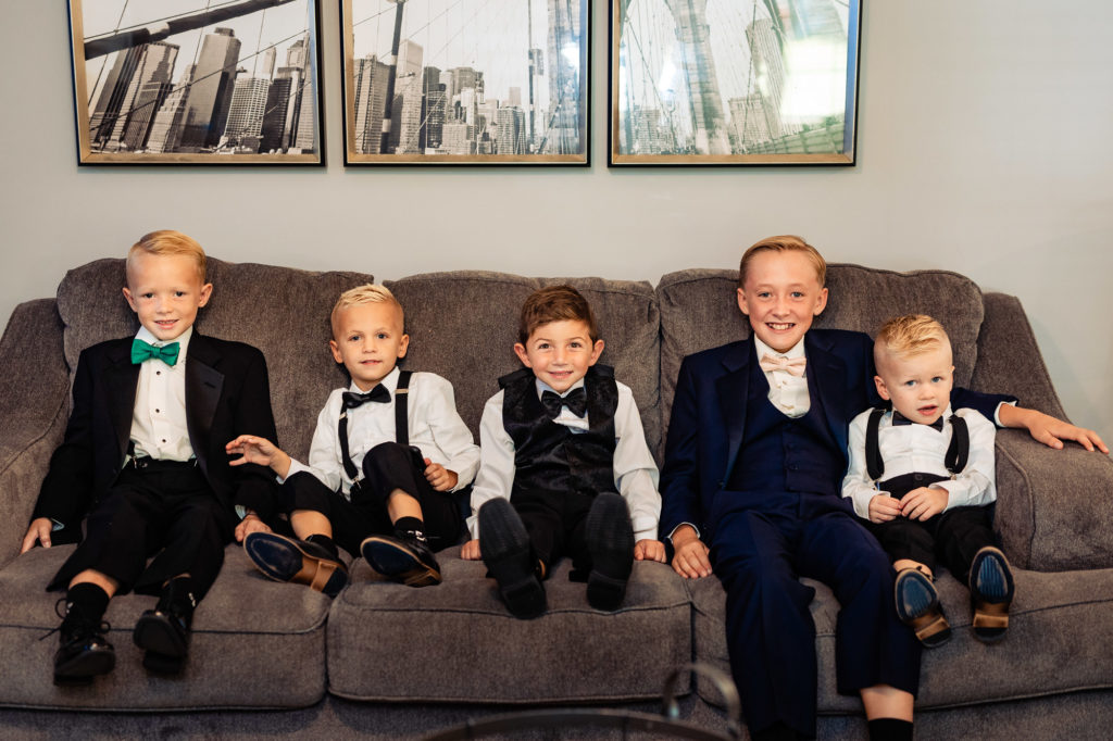 five little kids looking dapper while sitting on the couch