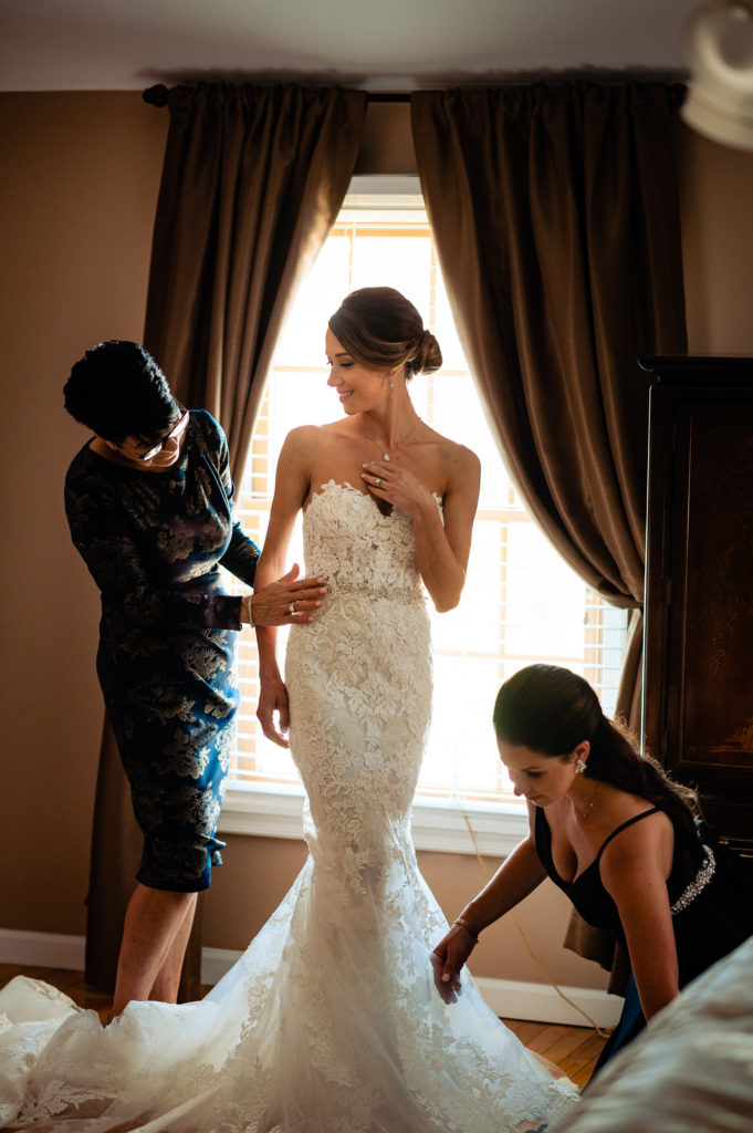 Bride getting ready with the help of her mother and maid-of-honor