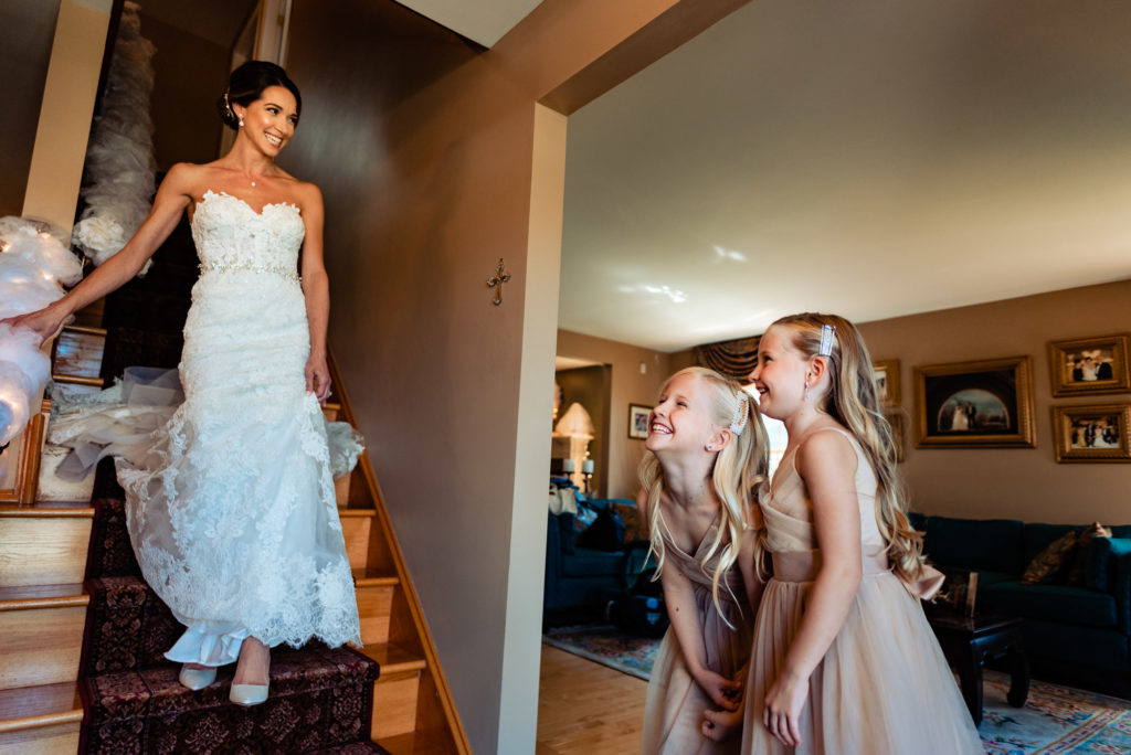 bride walking down the stair while 2 flower girls are waiting