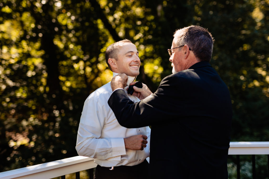 groom's father helping him with his tie