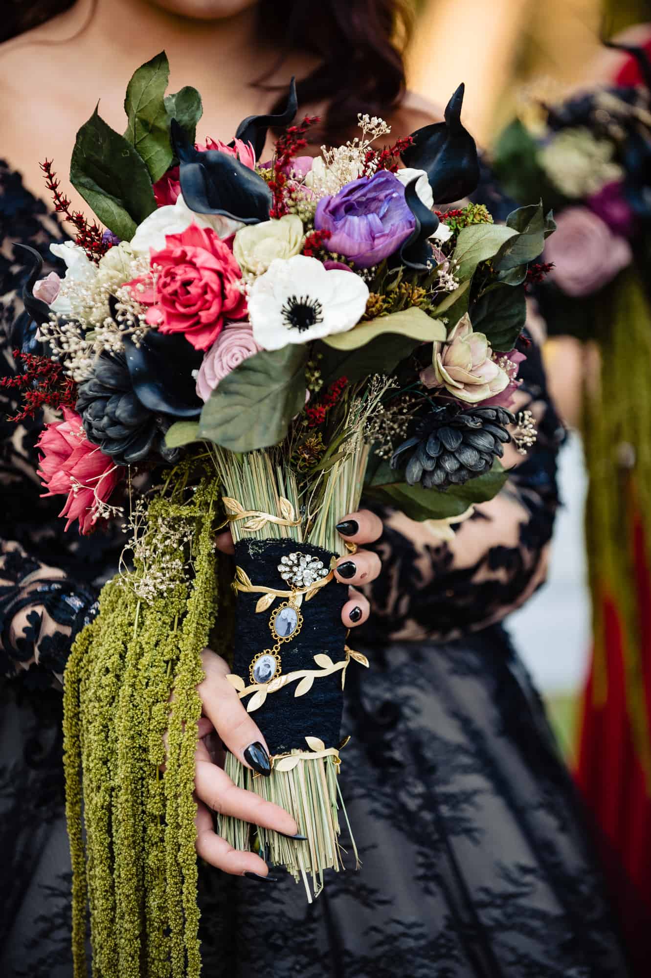 detailed shot of the bride's bouquet made of black and colored flowers and hay