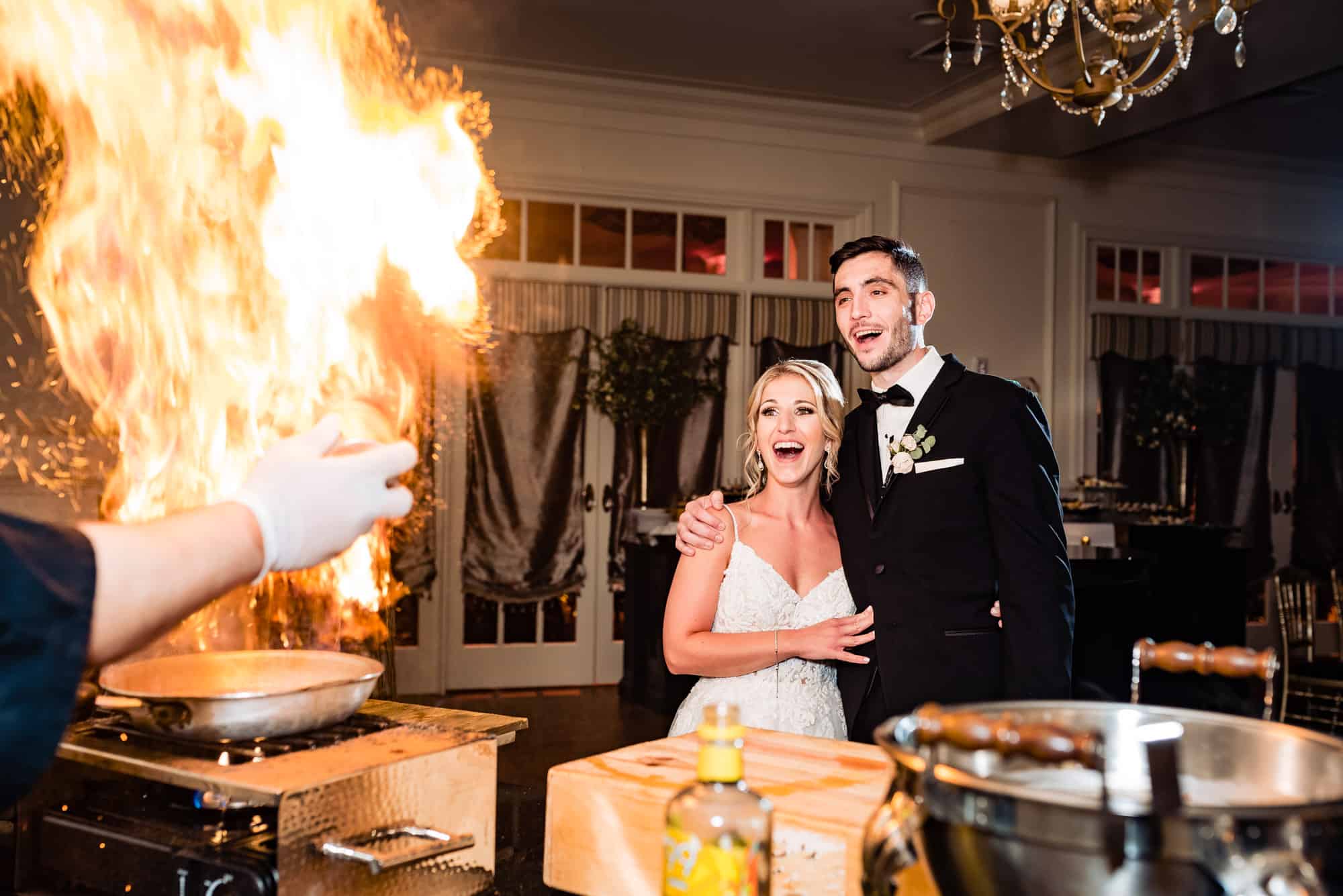 newlyweds are amazed with the culinary showmanship of the chef