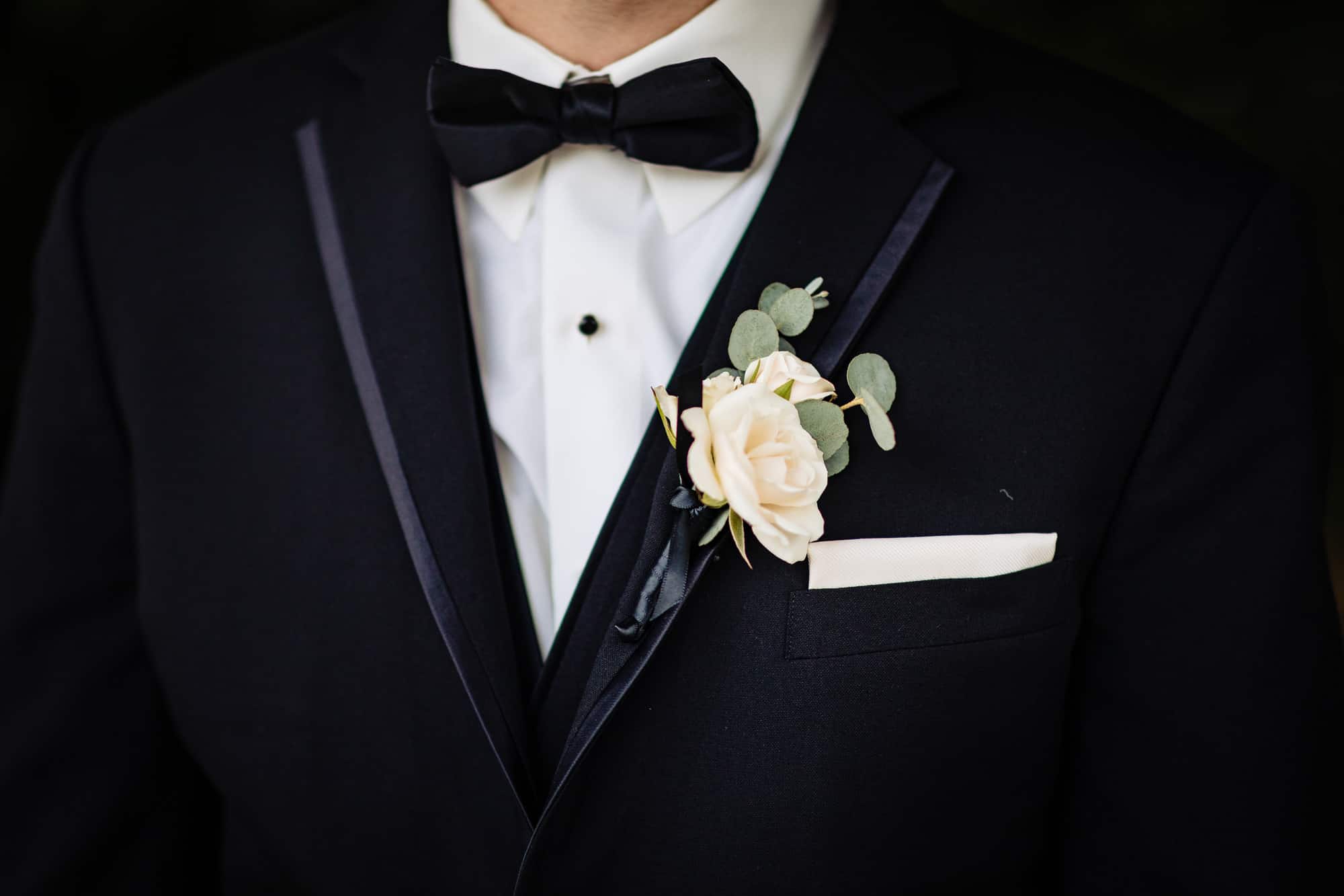 groom's boutonniere made of white rose