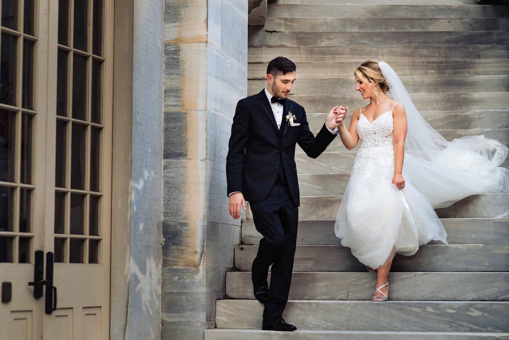 groom and bride walking down the stairs