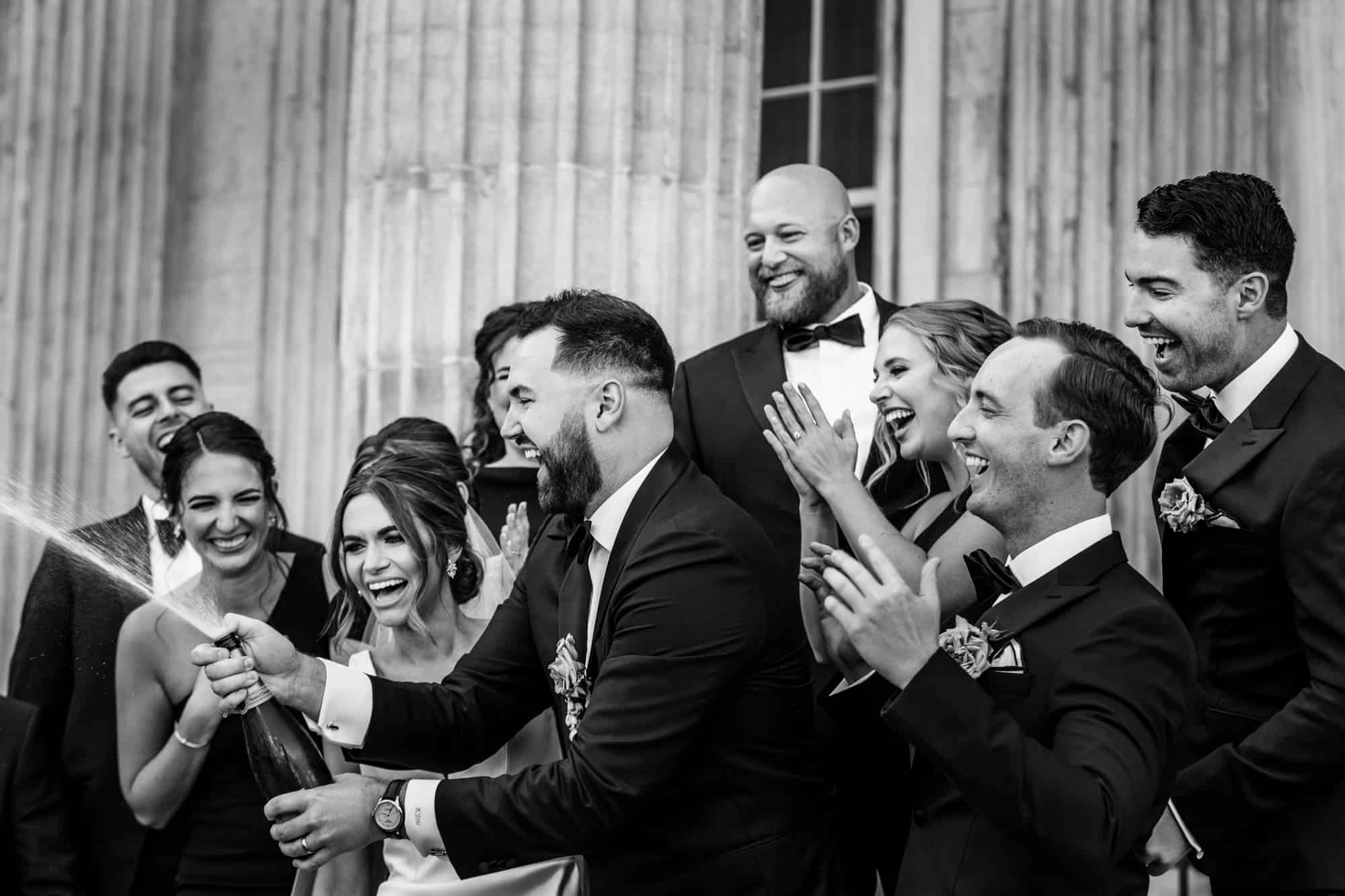 groom popping the wine bottle