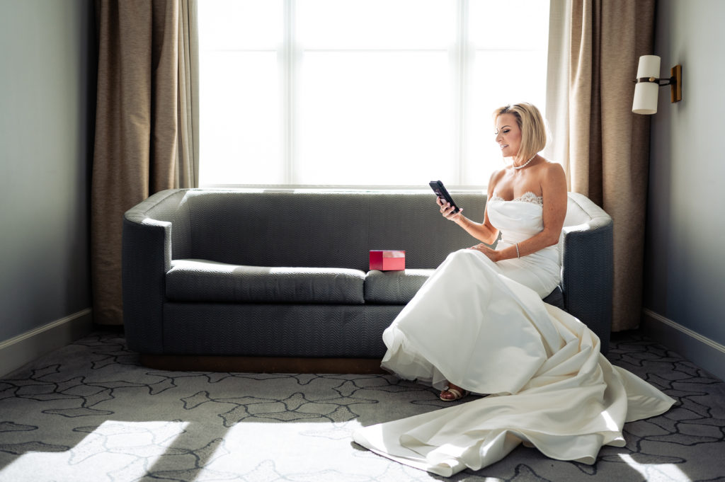 bride reading a text message at her suite at Ritz-Carlton Half Moon Bay