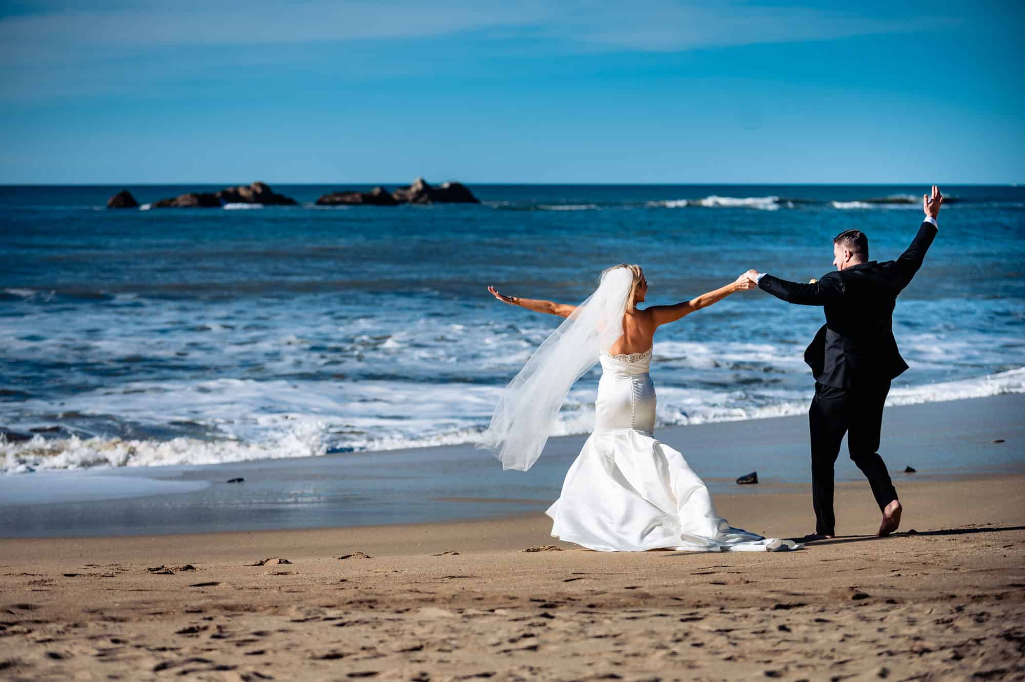 happy couple walking along the beach before the wedding outside the Ritz-Carlton Half Moon Bay