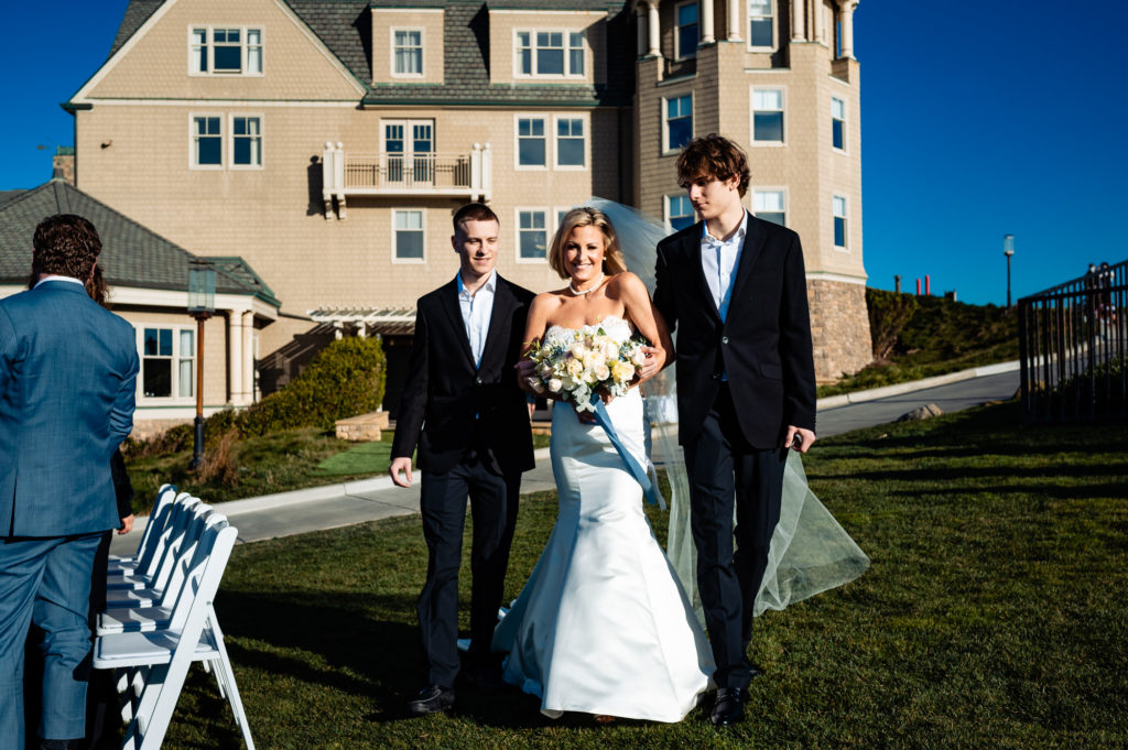 bride walking towards the altar at a beach wedding ceremony held outside the Ritz-Carlton Half Moon Bay